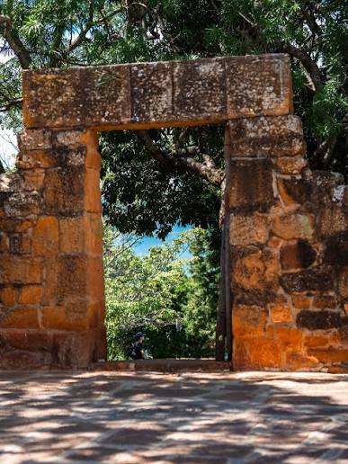 Portal de piedra colonial rodeado de árboles en el Cinturón Verde de Barichara